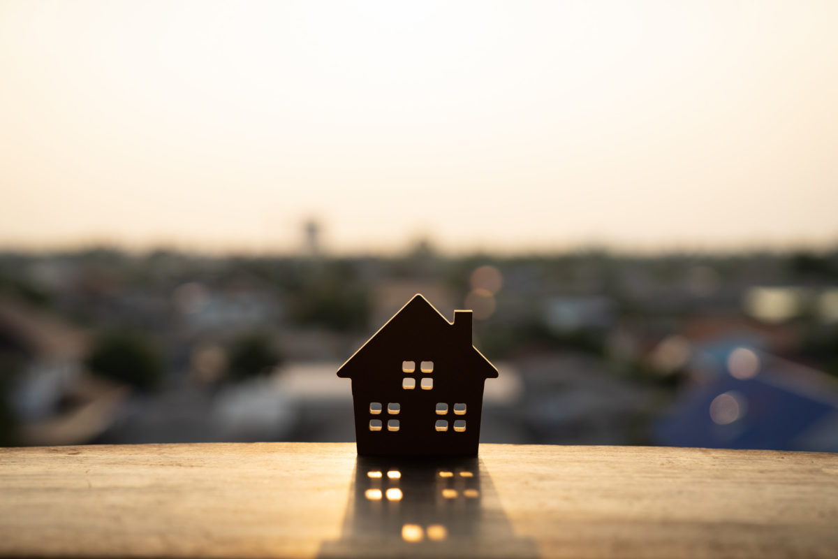 Small house on a ledge overlooks large suburban neighborhood