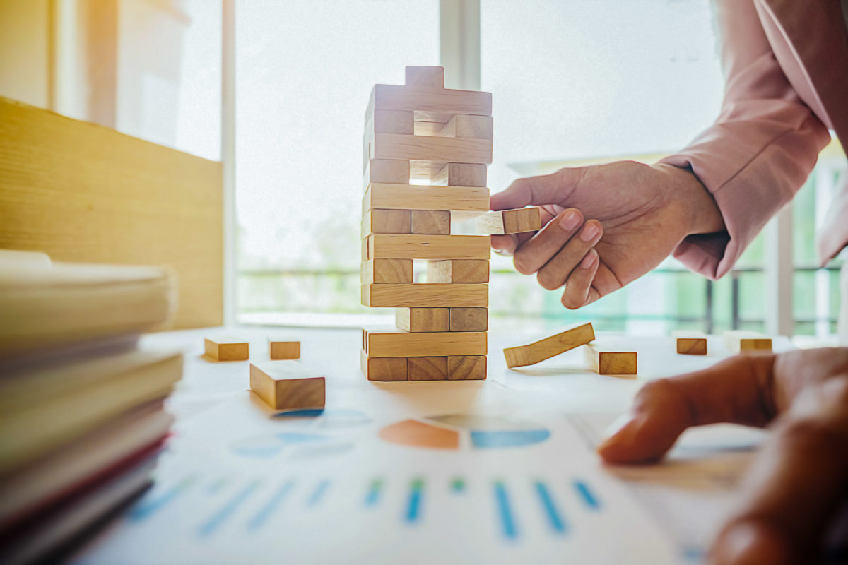 Small business owner protecting their business from risk like a game of jenga