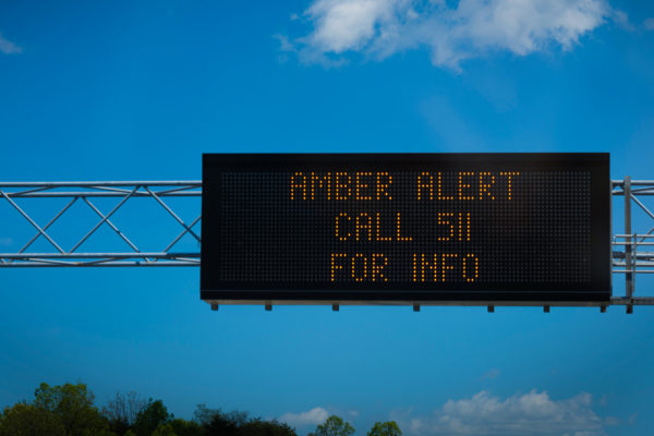 Amber alert flashes on highway road sign