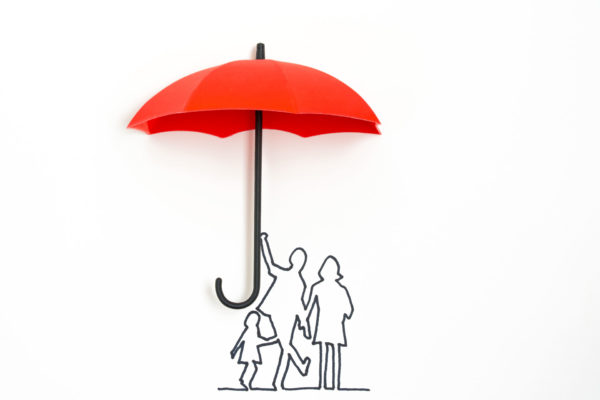 family standing under red umbrella as a metaphor for a life insurance policy