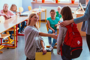 Teacher greets student to class where she will teach them to be responsible