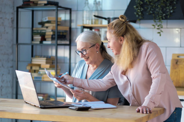 woman helps her elderly mother signup for medicare