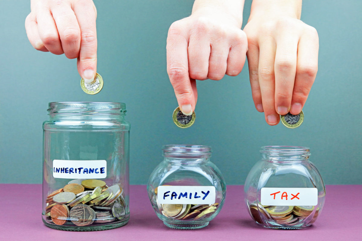 hands deposit coins in money jars labeled inheritance and taxes