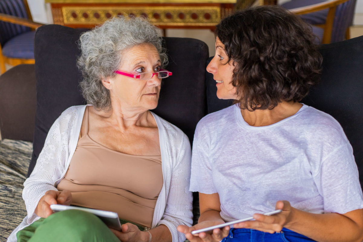 young woman discusses estate planning with her elderly parent