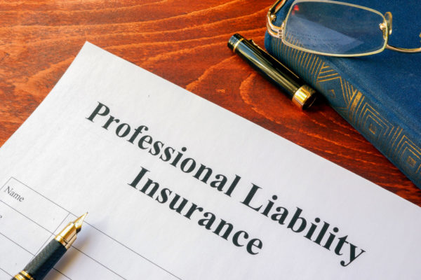 documents on a desktop titled professional liability insurance