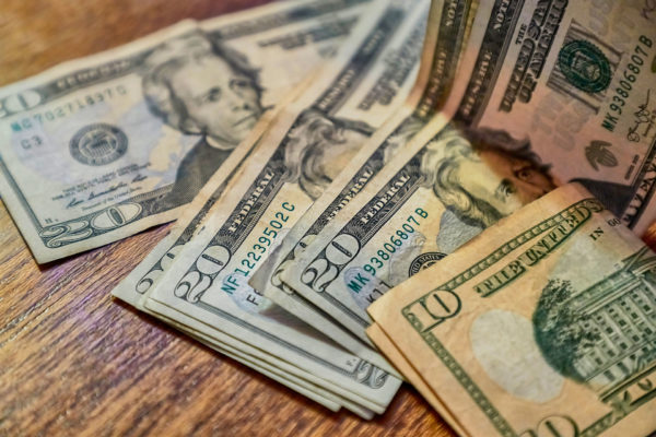 closeup of US dollar bills involved in new mandatory pay raise legislation