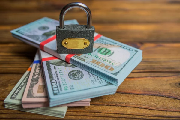 lock stacked on top of stacks of money resulting a domestic asset protection trust