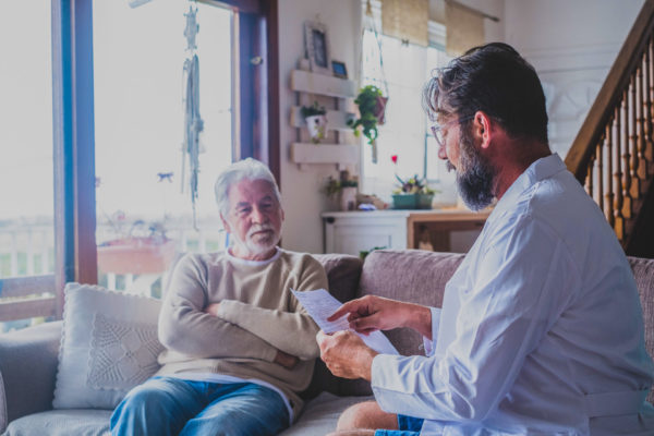 middle-aged man discusses estate planning with his elderly loved one