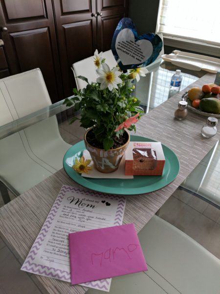 mother's day card and envelope next to plant and donut