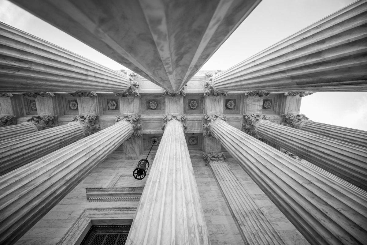 Looking up at vertical columns outside courthouse.