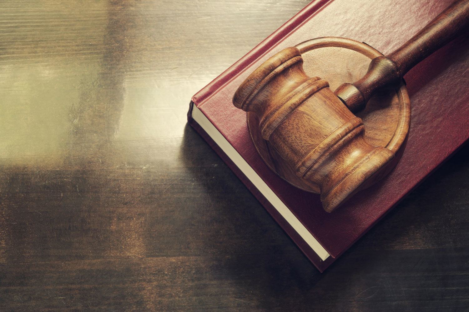 Courtroom gavel and book on top of desk.