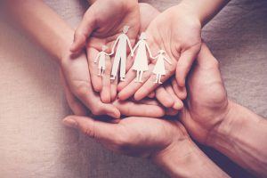 hands holding family paper cutout